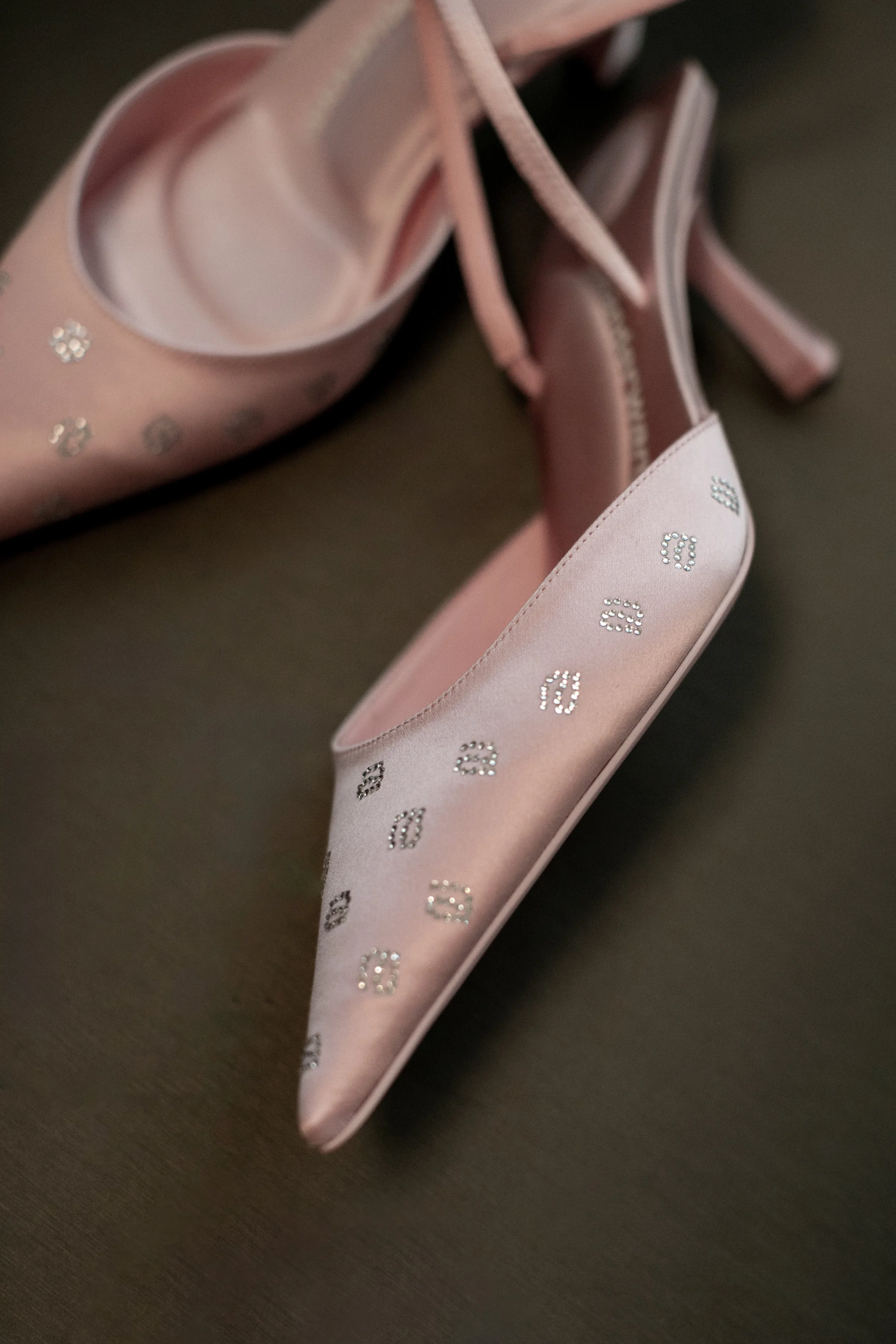 Pink satin high-heeled shoes with rhinestone-studded numbers