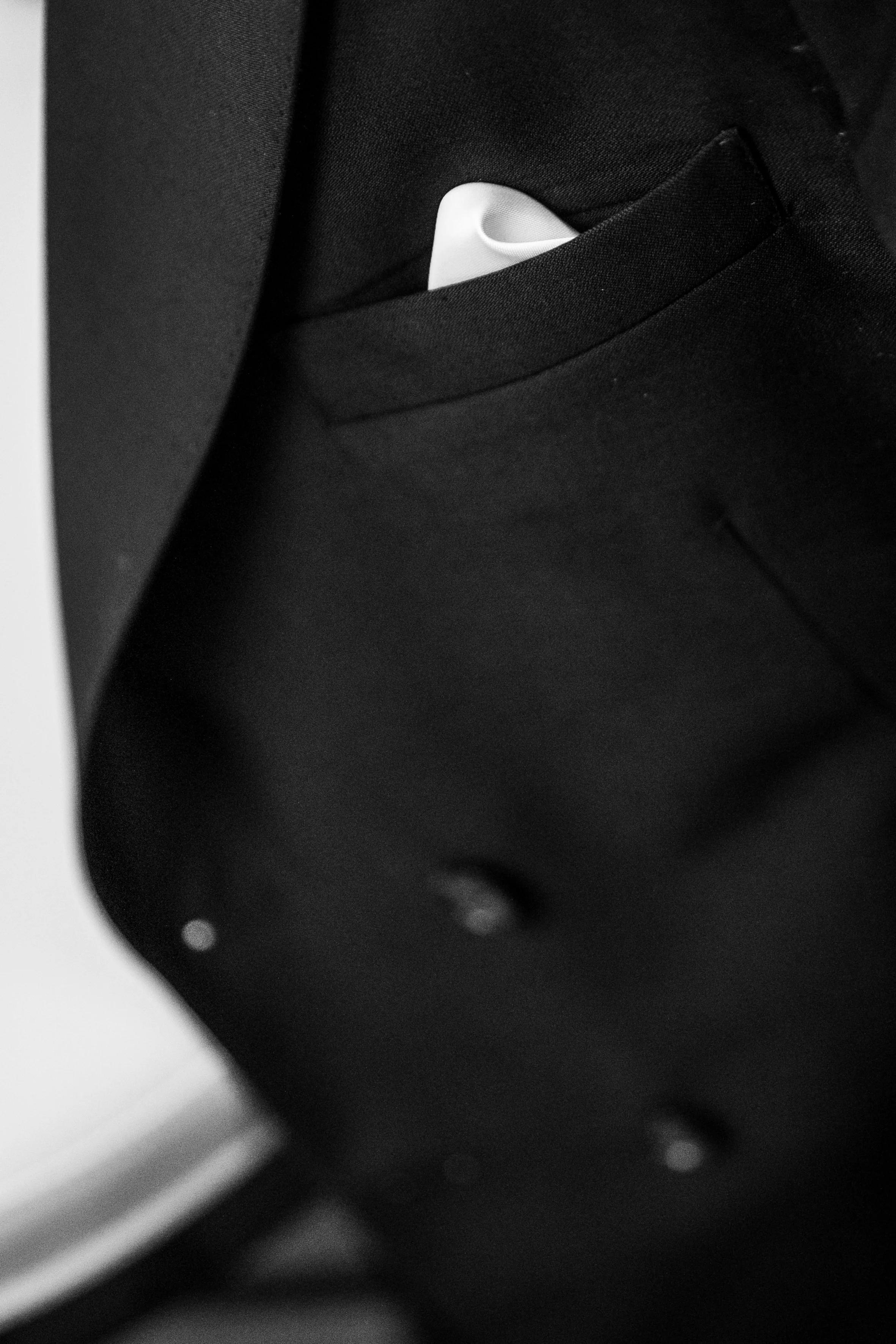 Close-up of a black briefcase with a white AirPods case visible in the front pocket.