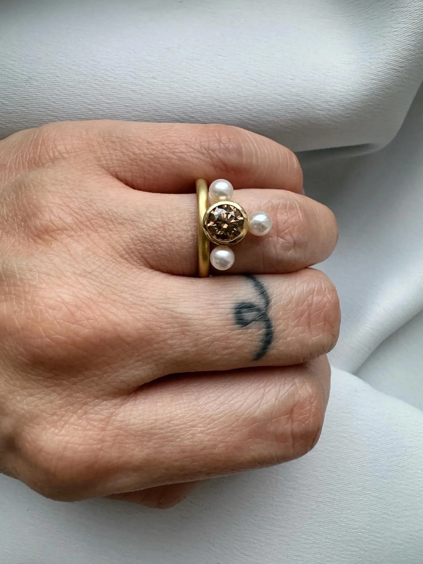 The Nearly Compass Ring, part of my One Of A Kind collection presents a play on order and arrangement with an off centre band and nearly-but-not-quite complete pearl compass emblem, focused around a rich cognac brown diamond.🧭