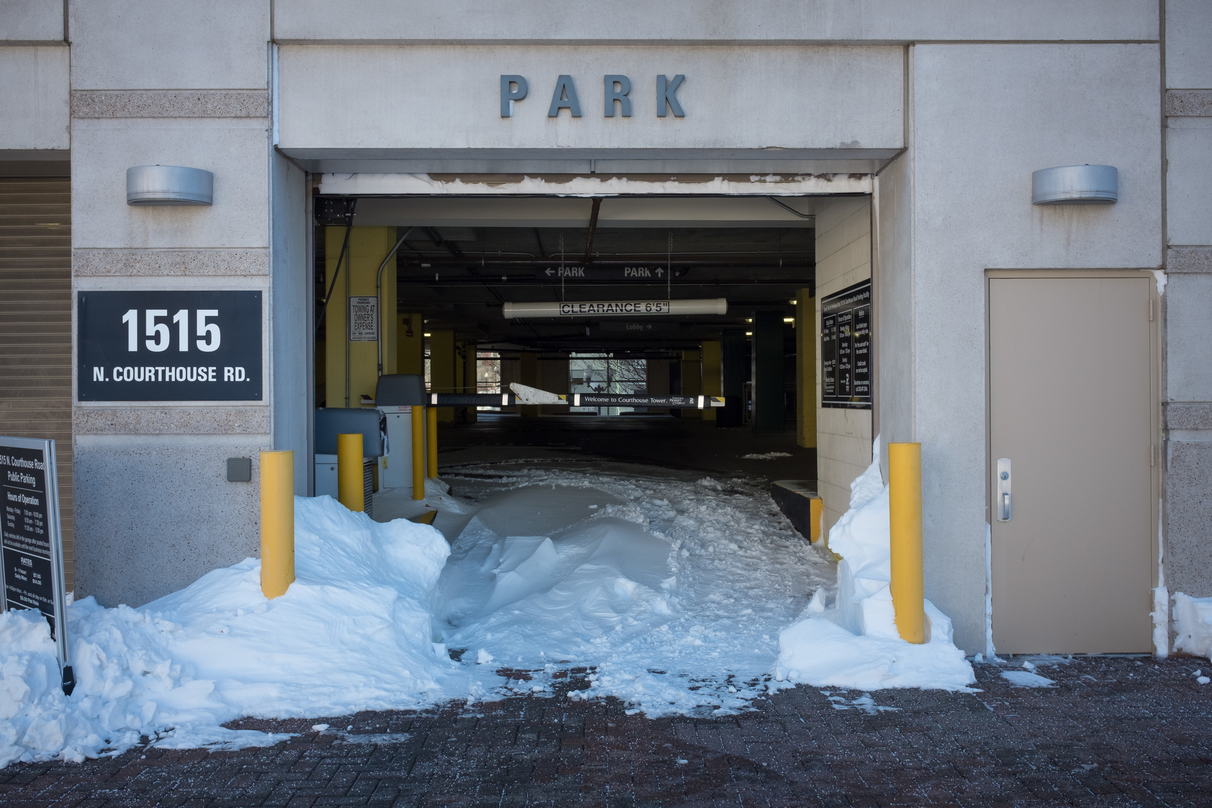 What drew my eye to this scene was just how far-reaching and intrusive the snow was, even entering the parking garage that no cars had entered. I also like the symmetry of the opening and the splash of color from the poles.