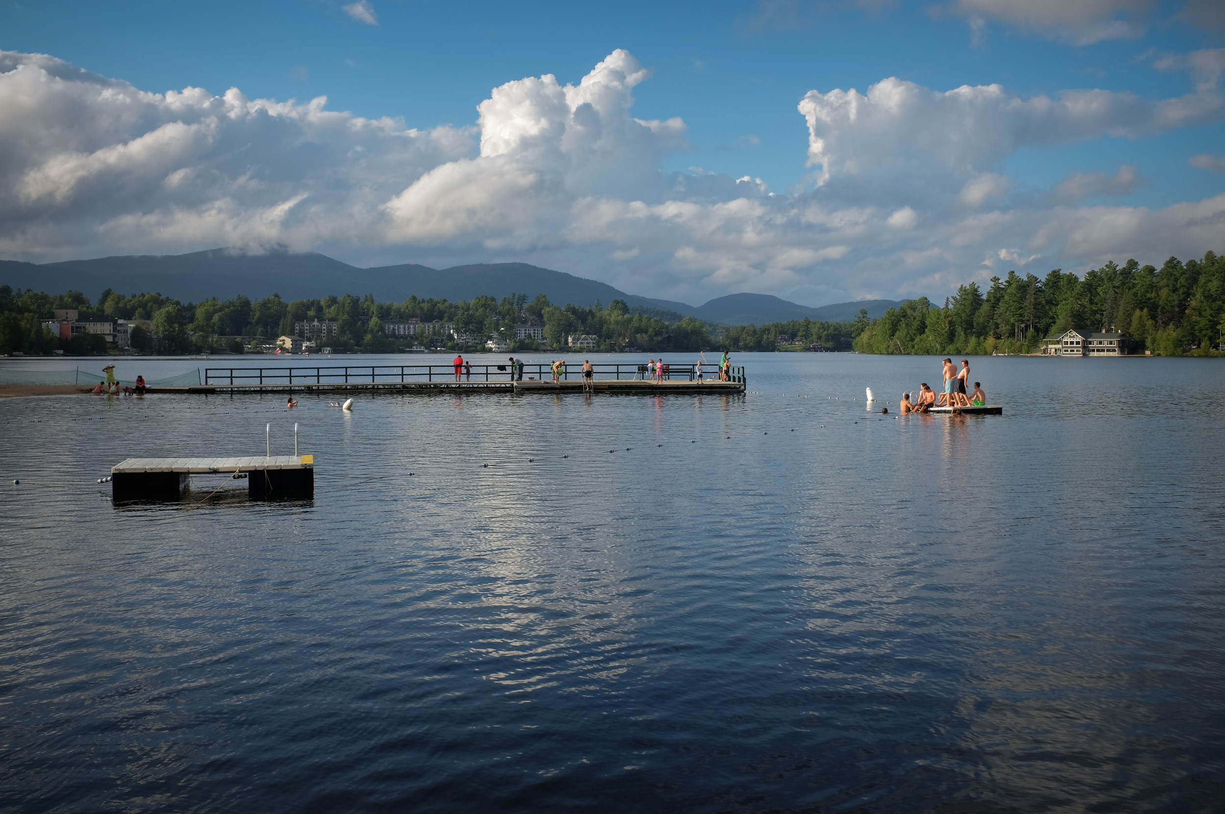 The early evening light highlights swimmers at the public beach on Lake Mirror located in Lake Placid, N.Y. 1/300 @ f8, ISO 200.