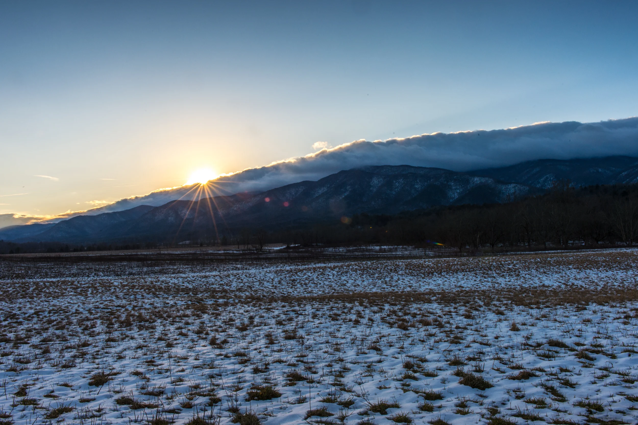 Switched to the 24-70mm with a Cokin split neutral density filter just as the sun rose above the clouds. You can see how the clouds just stuck to the top of the mountains. 1/60 @ f22, ISO 200.