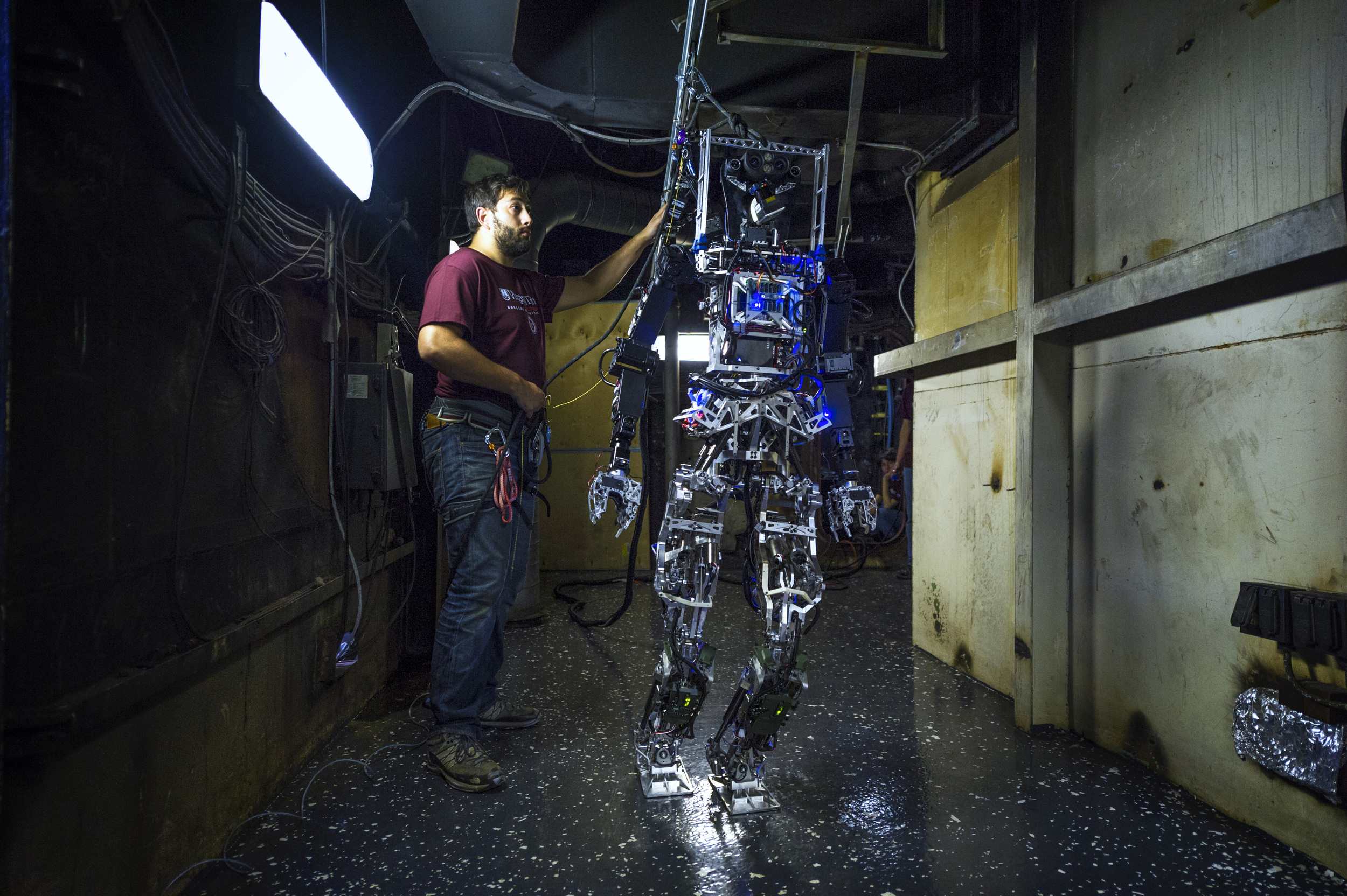 MOBILE, Ala . - John Seminatore, a graduate student at Virginia Tech, secures the Office of Naval Research-sponsored Shipboard Autonomous Firefighting Robot (SAFFiR) during testing aboard the Naval Research Laboratory's ex-USS Shadwell in Mobile, Ala. The bipedal humanoid robot, developed as a test bed for autonomous firefighting and damage control operations, was tethered to a power source for demonstrations aboard the Navy's fire test platform.