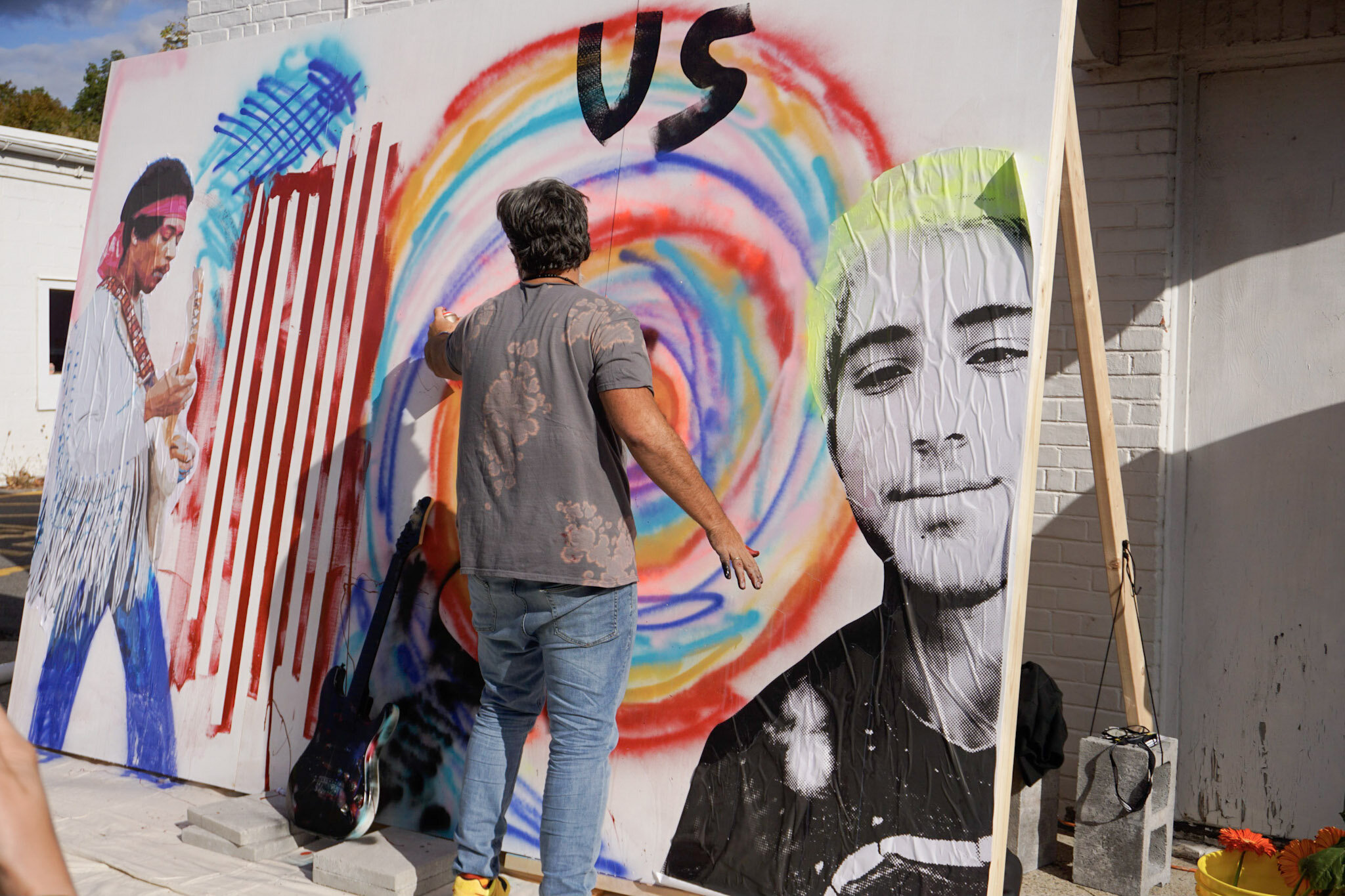 Manuel Oliver works on his mural in the center of Woodstock.