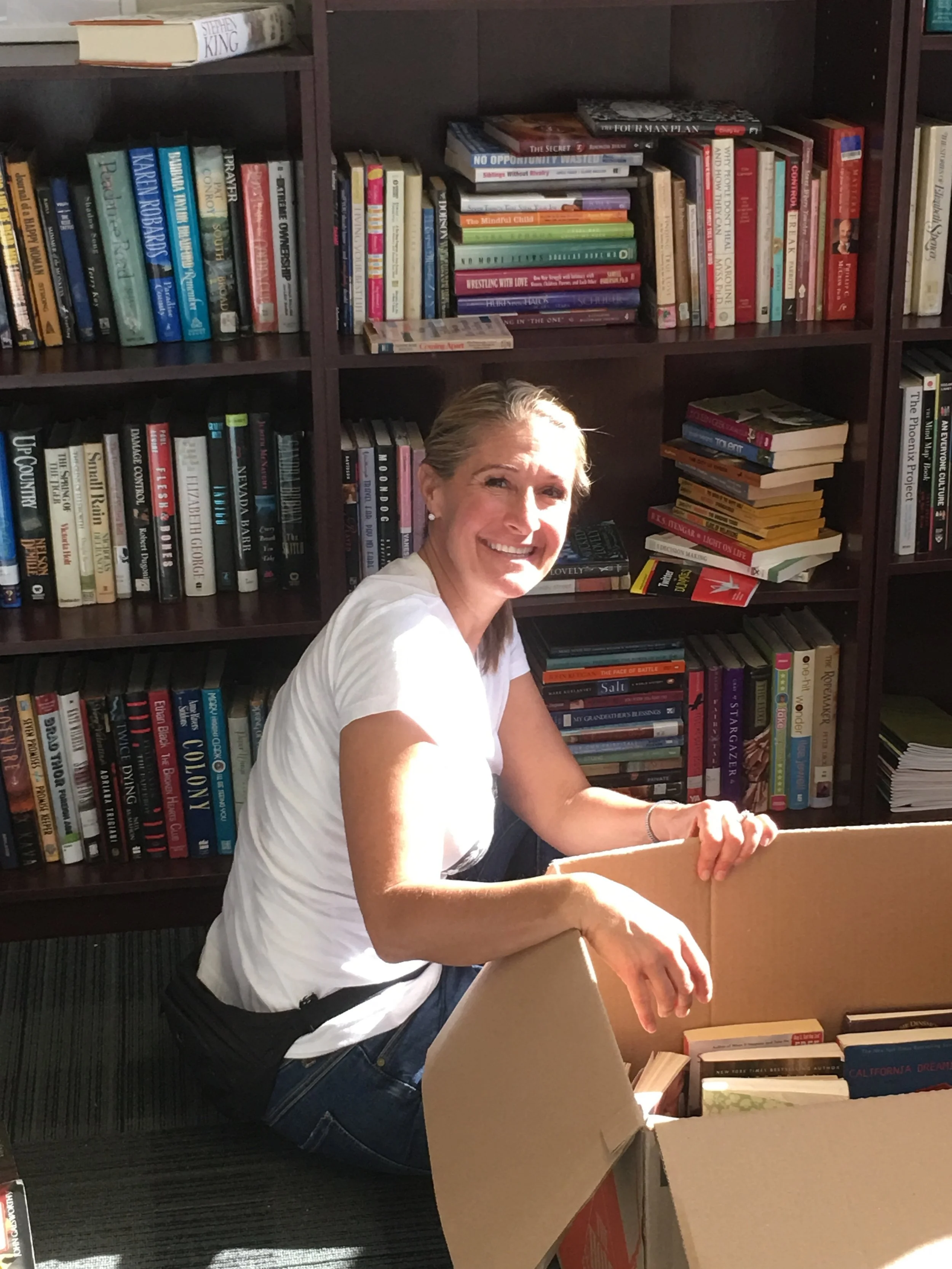 Board Member sorting and placing books.