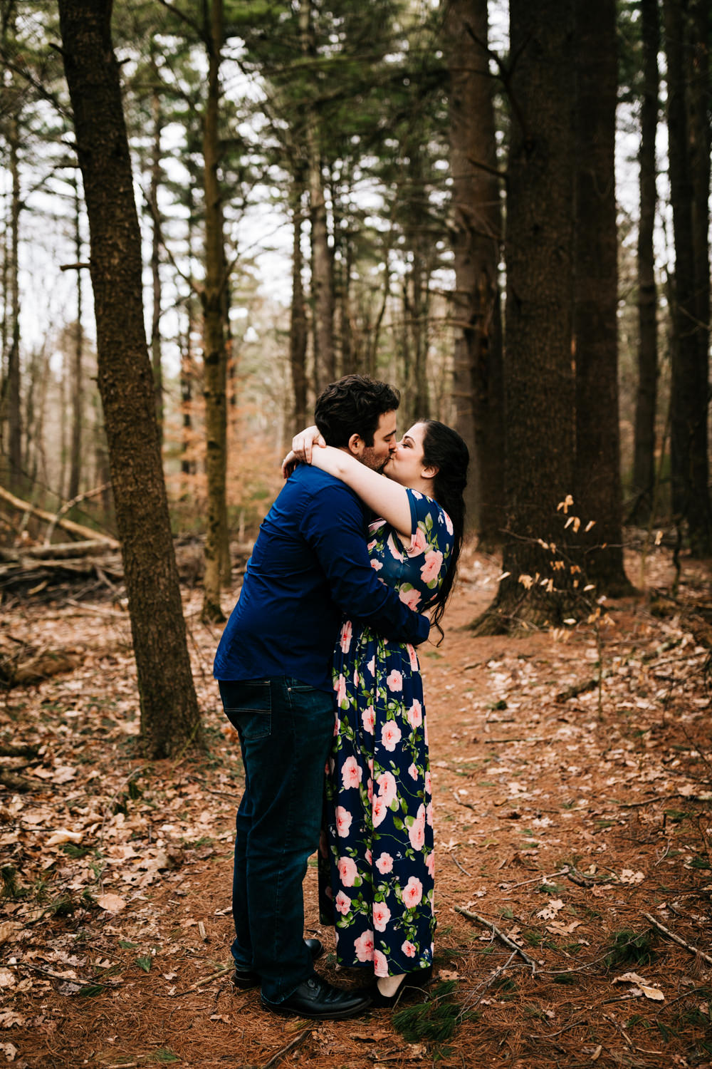 Adventurous couple kissing in the woods of Boston