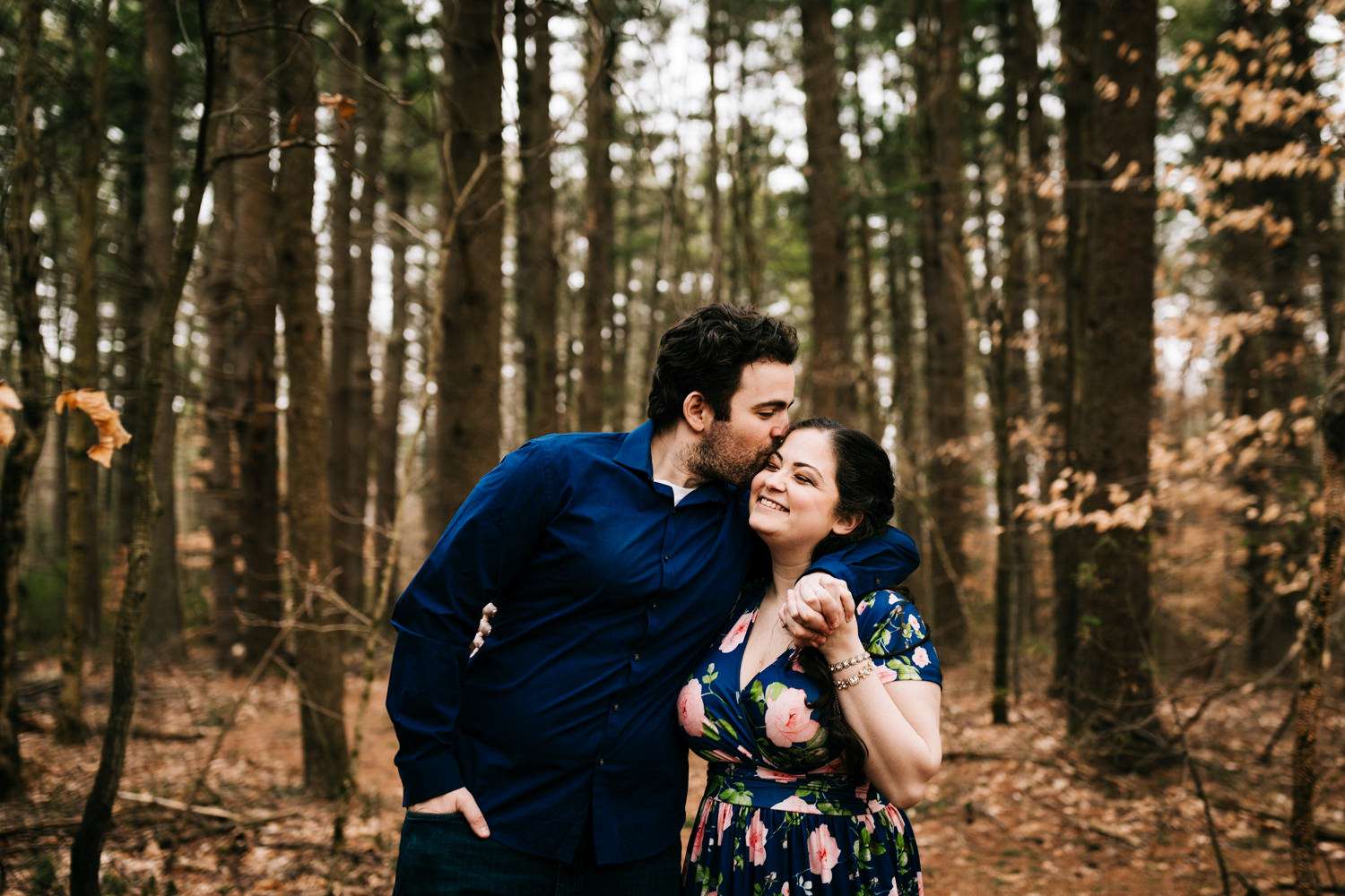 Man kissing floral dress wearing woman in woods near Santa Fe