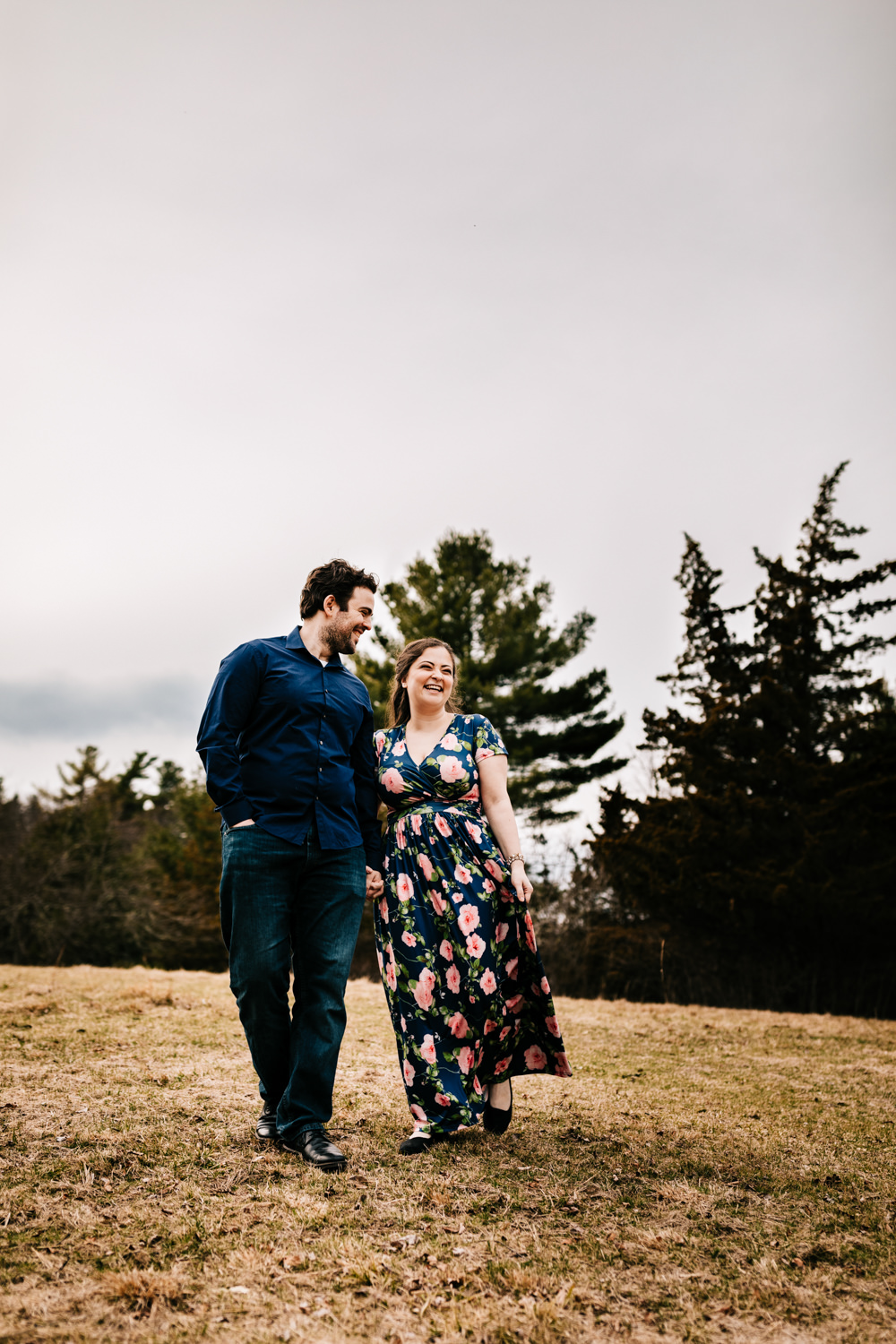 Couple walking through grassy field in April in Massachusetts