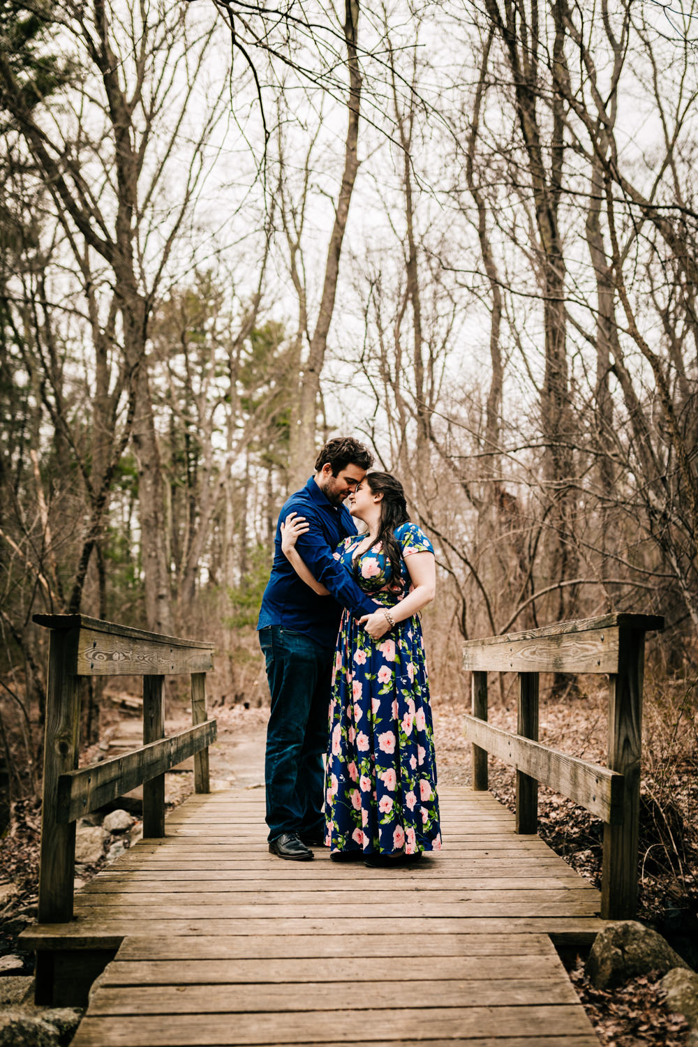 Couple embracing on a bridge in a wildlife preserve in Boston