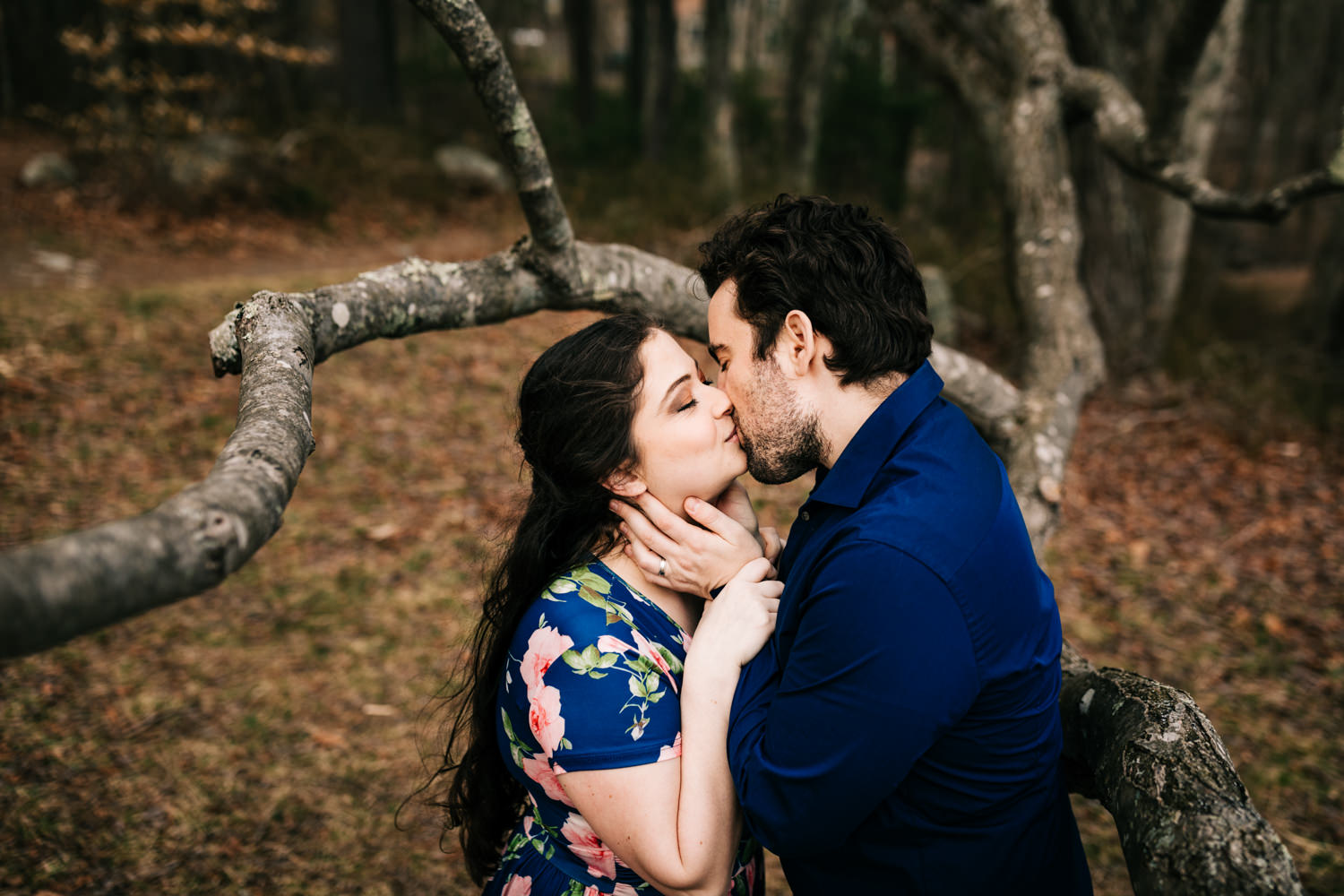 Husband and wife kissing under tree in wildlife preserve near Boston