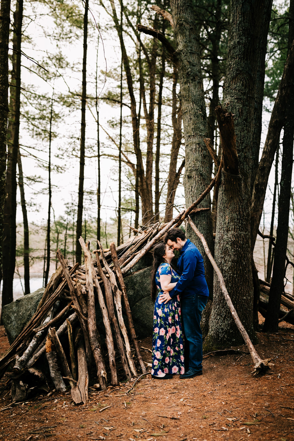 Couple by a makeshift woodland shelter in Massachusetts