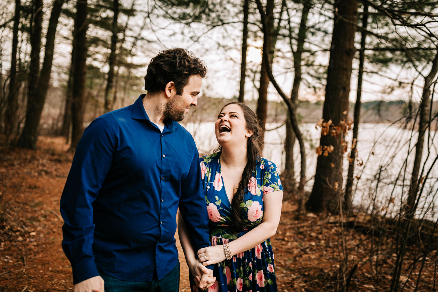 Couple laughing on hiking trail in woods of New England