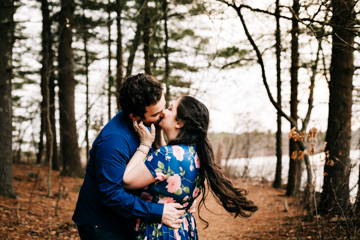 Adventurous husband and wife kissing with wind in hair in wildlife sanctuary in Boston