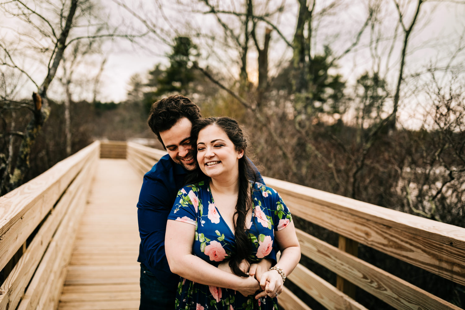 Husband and wife hugging on boardwalk on nature trail in New Mexico