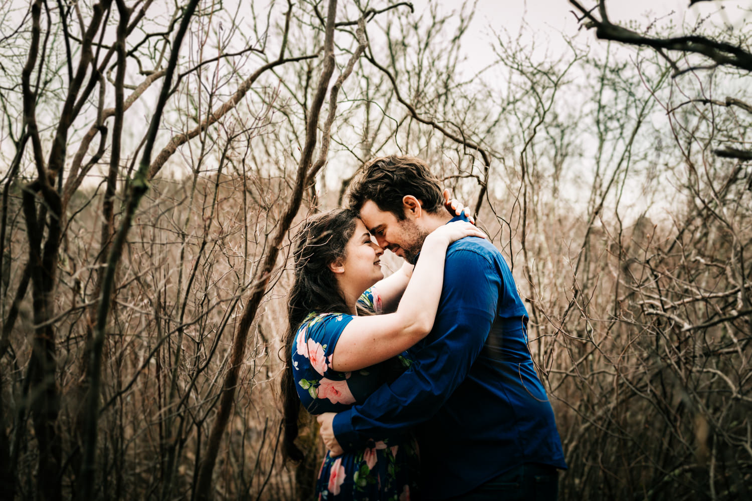 Couple embracing in brambles of forest in Massachusetts