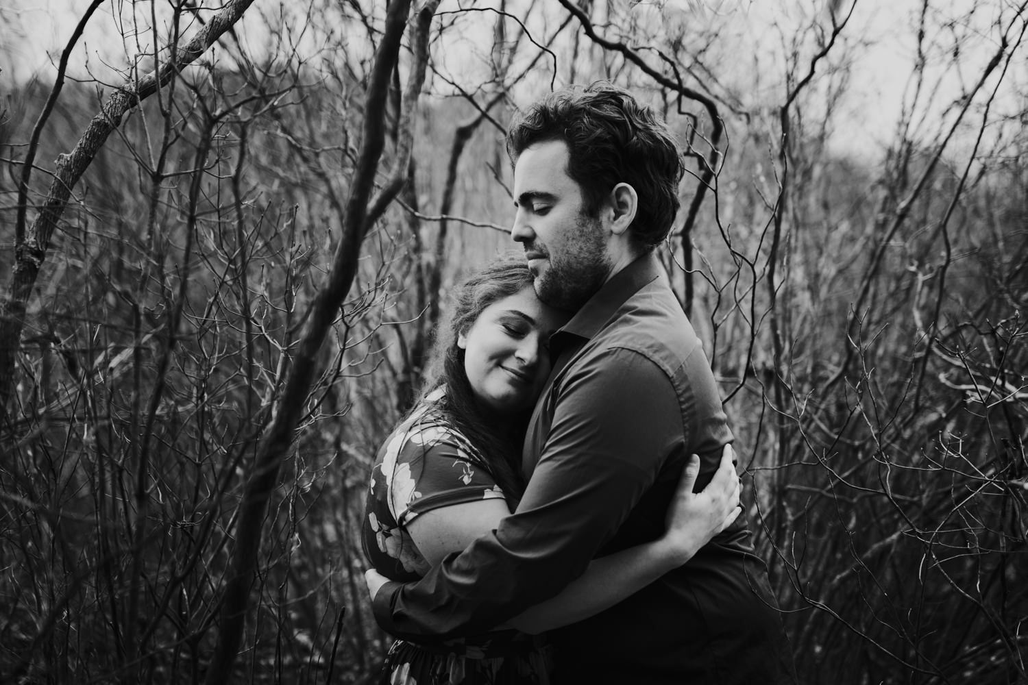 Couple embracing in brambles of forest in Massachusetts