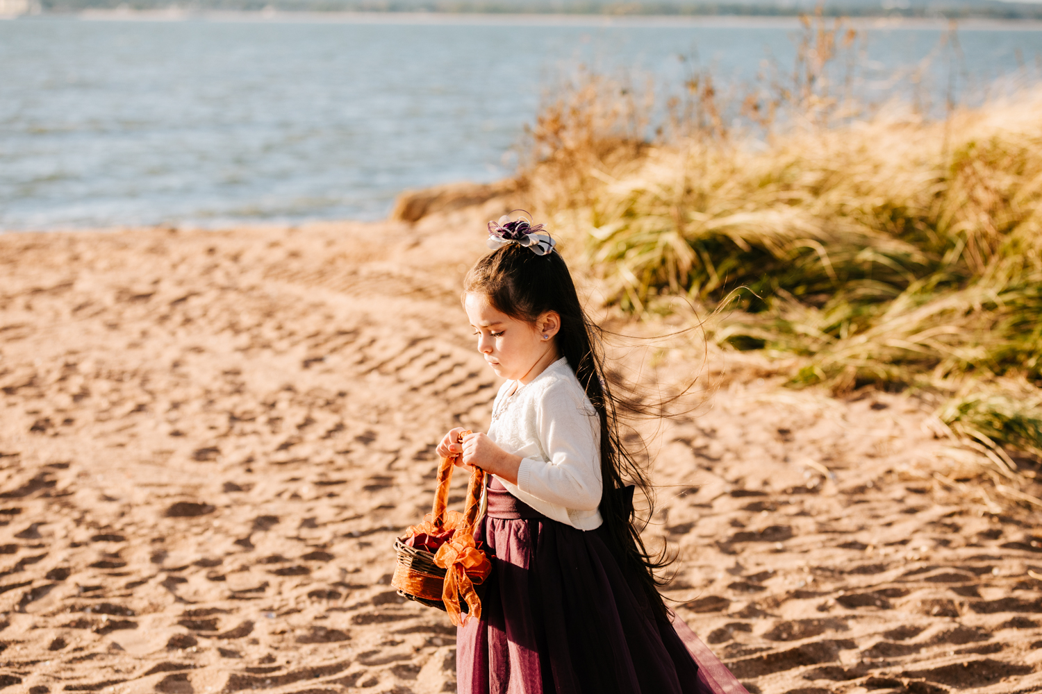 Flower girl wearing purple skirt on beach wedding