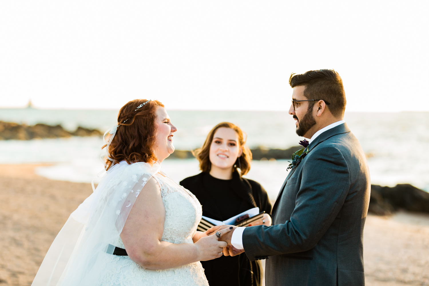 Bride and groom holding hands on beach wedding ceremony