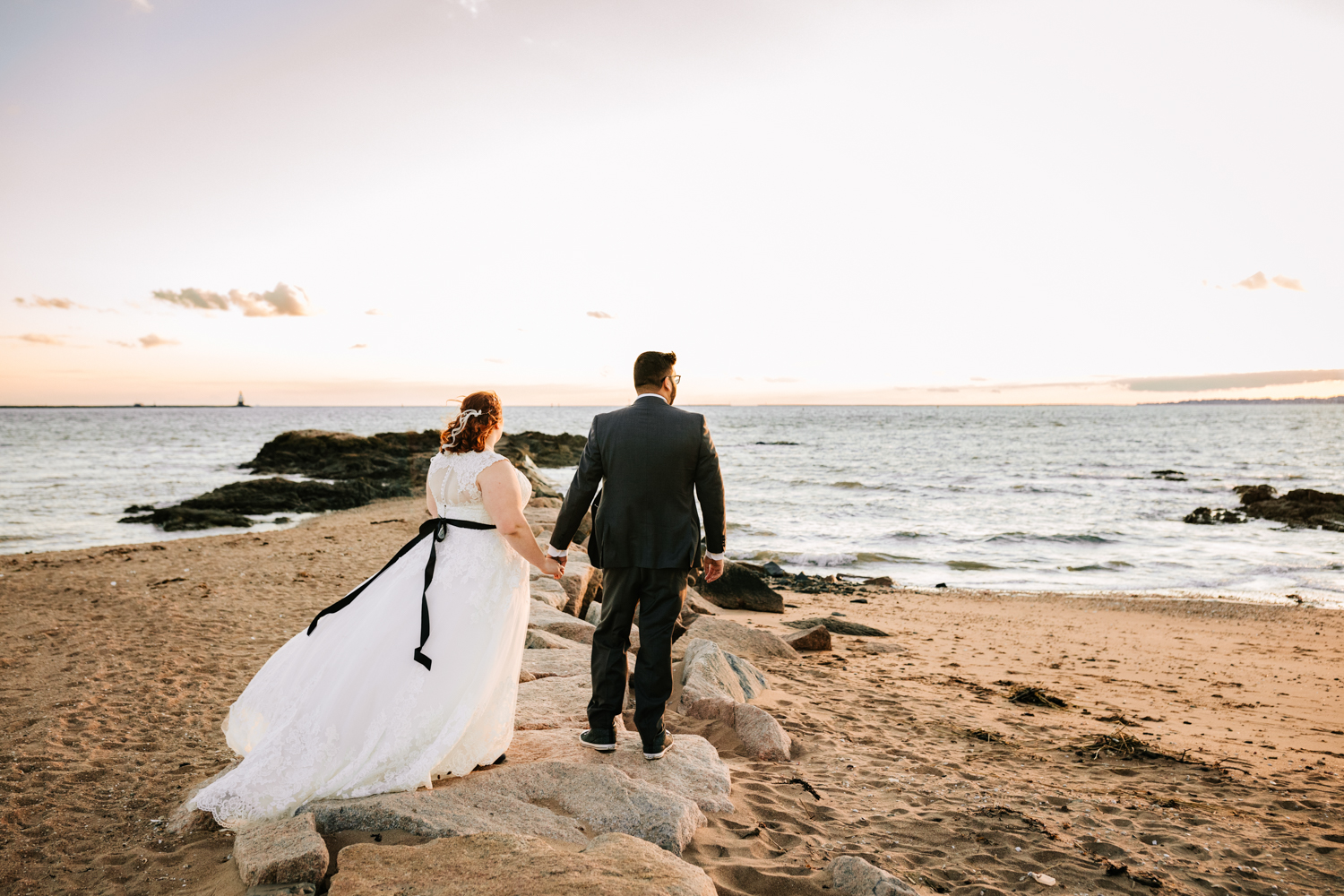 Bride and groom looking at sunset at ocean wedding