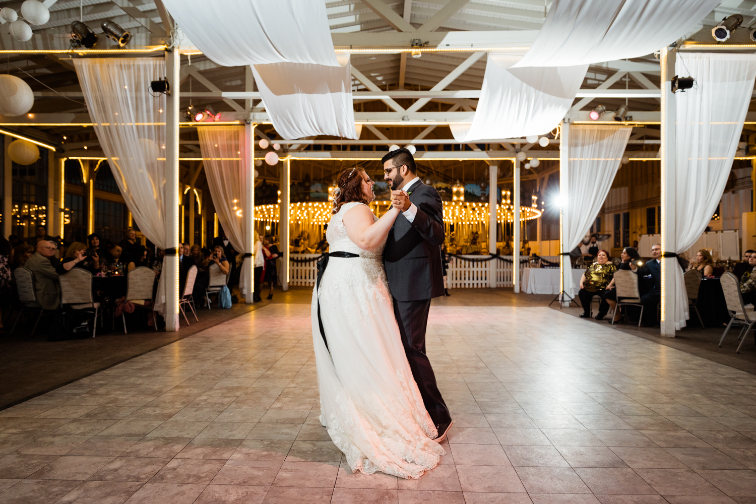 Bride and groom dancing in front of merry-go-round on wedding