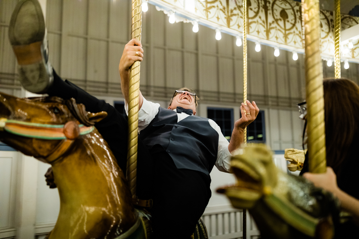 Bride's dad laughing on carousel on wedding day