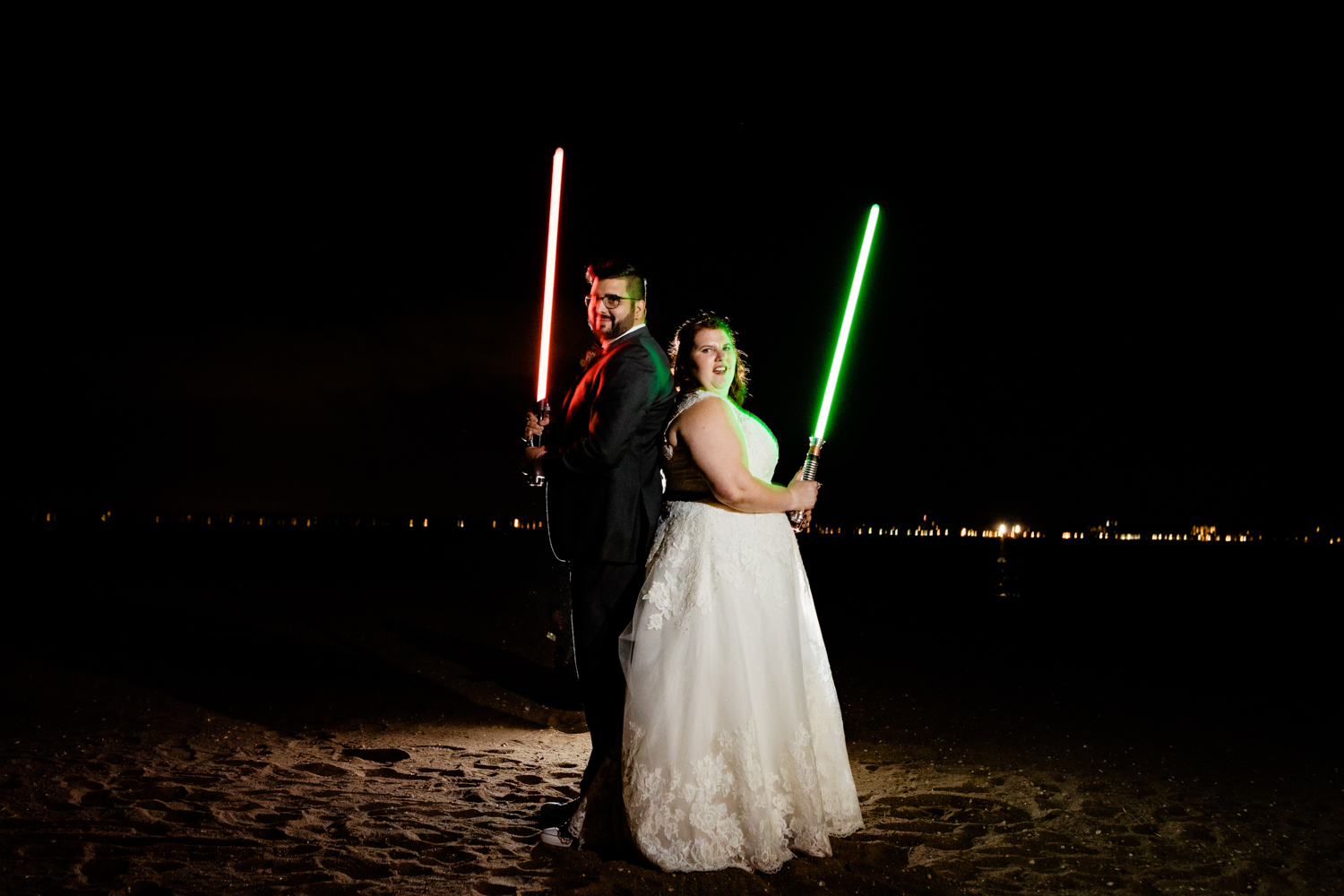 Bride and groom in the dark with lightsabers at star wars themed wedding