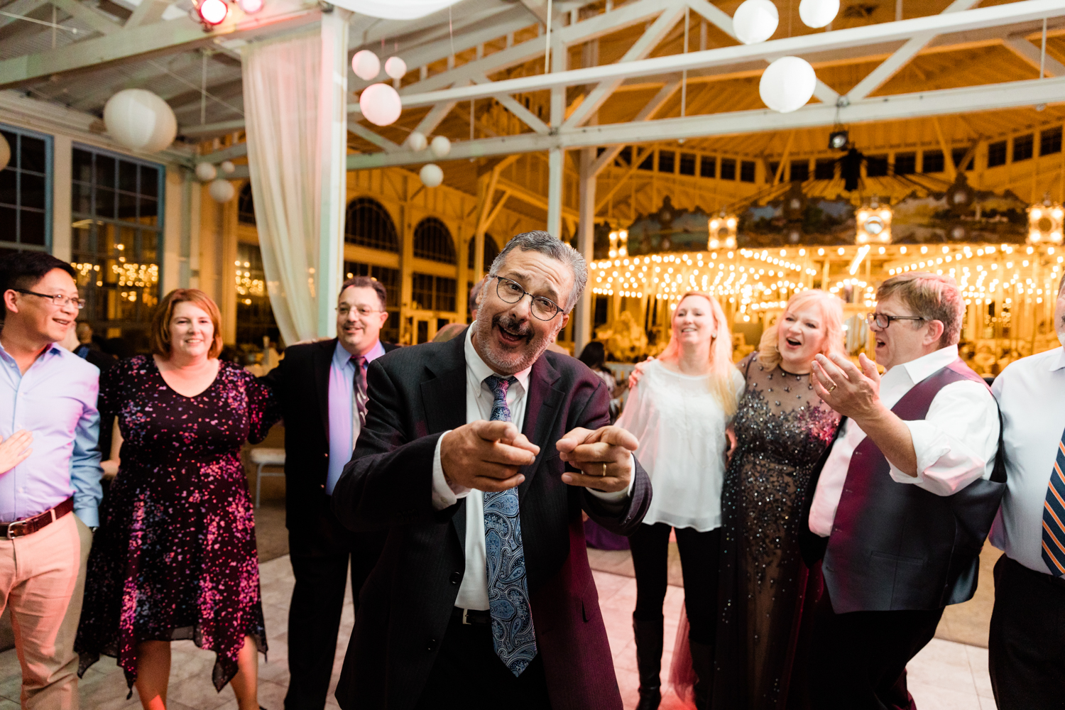 Guests dancing on wedding day with carousel