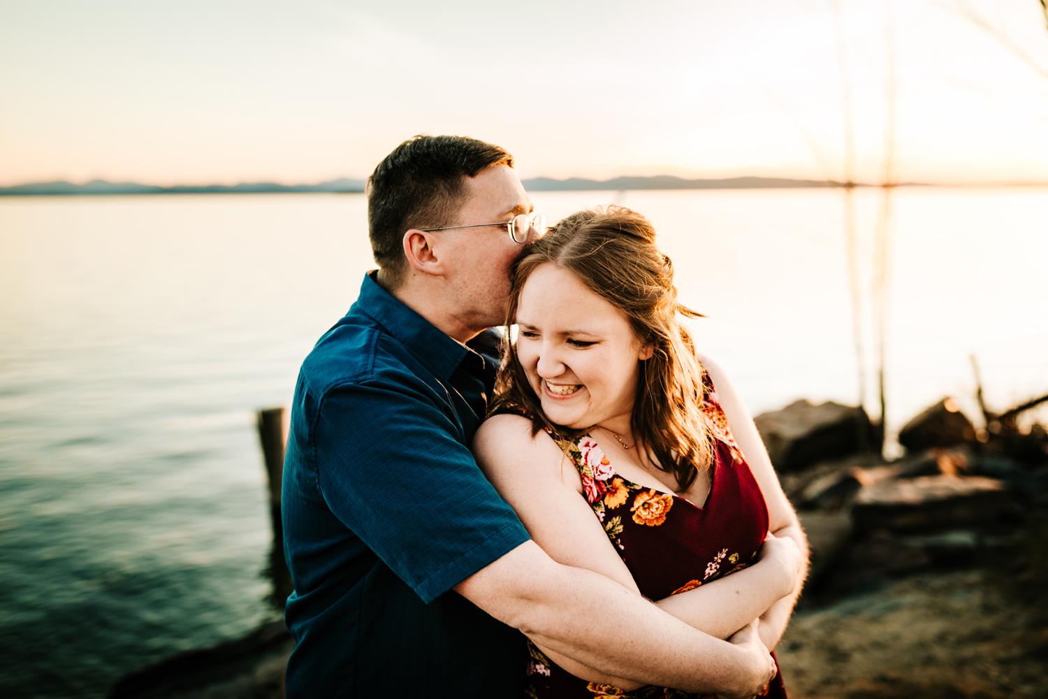 Man kissing engaged woman on natural beach