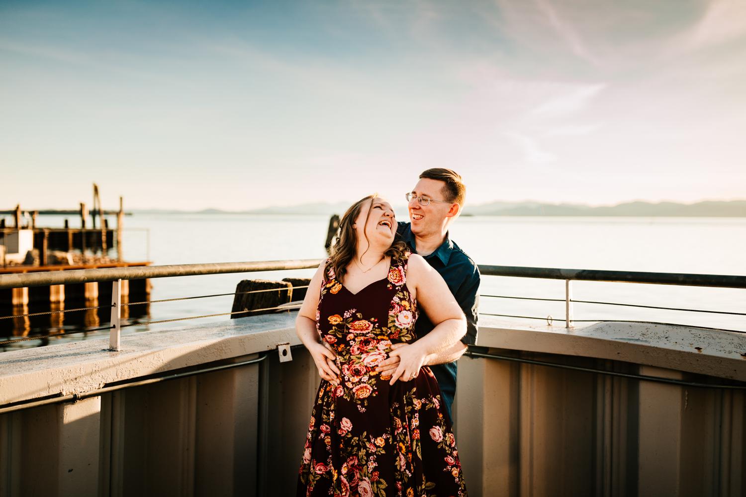 Laughing adventurous couple in front of natural lake and mountains