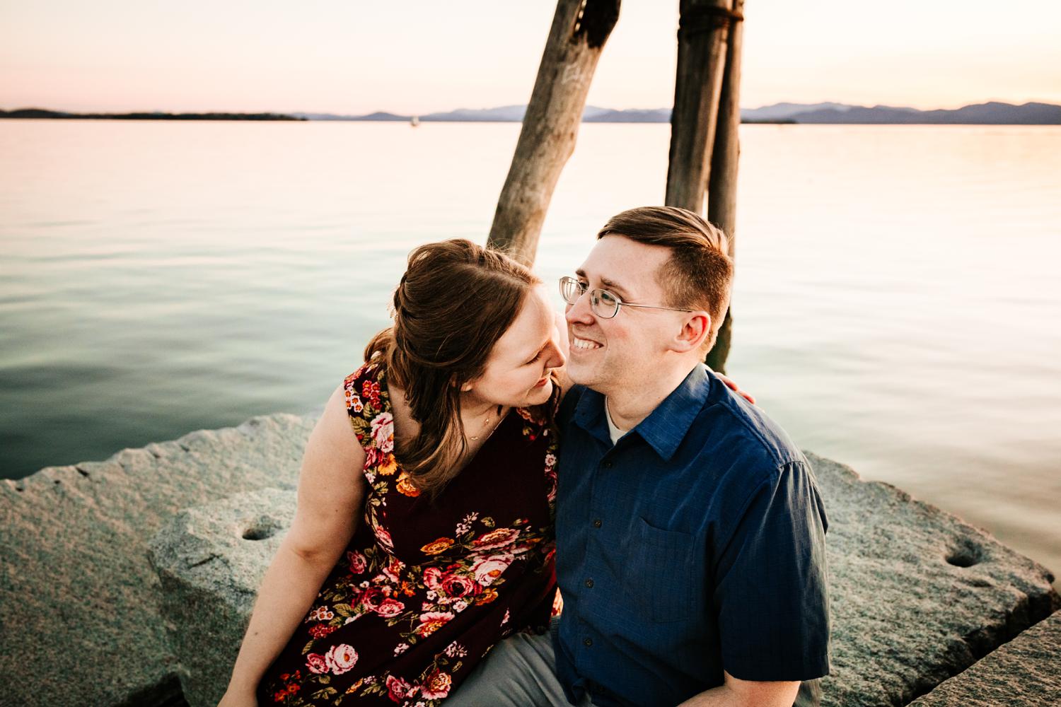 Adventurous couple sitting at lake with mountains in the background