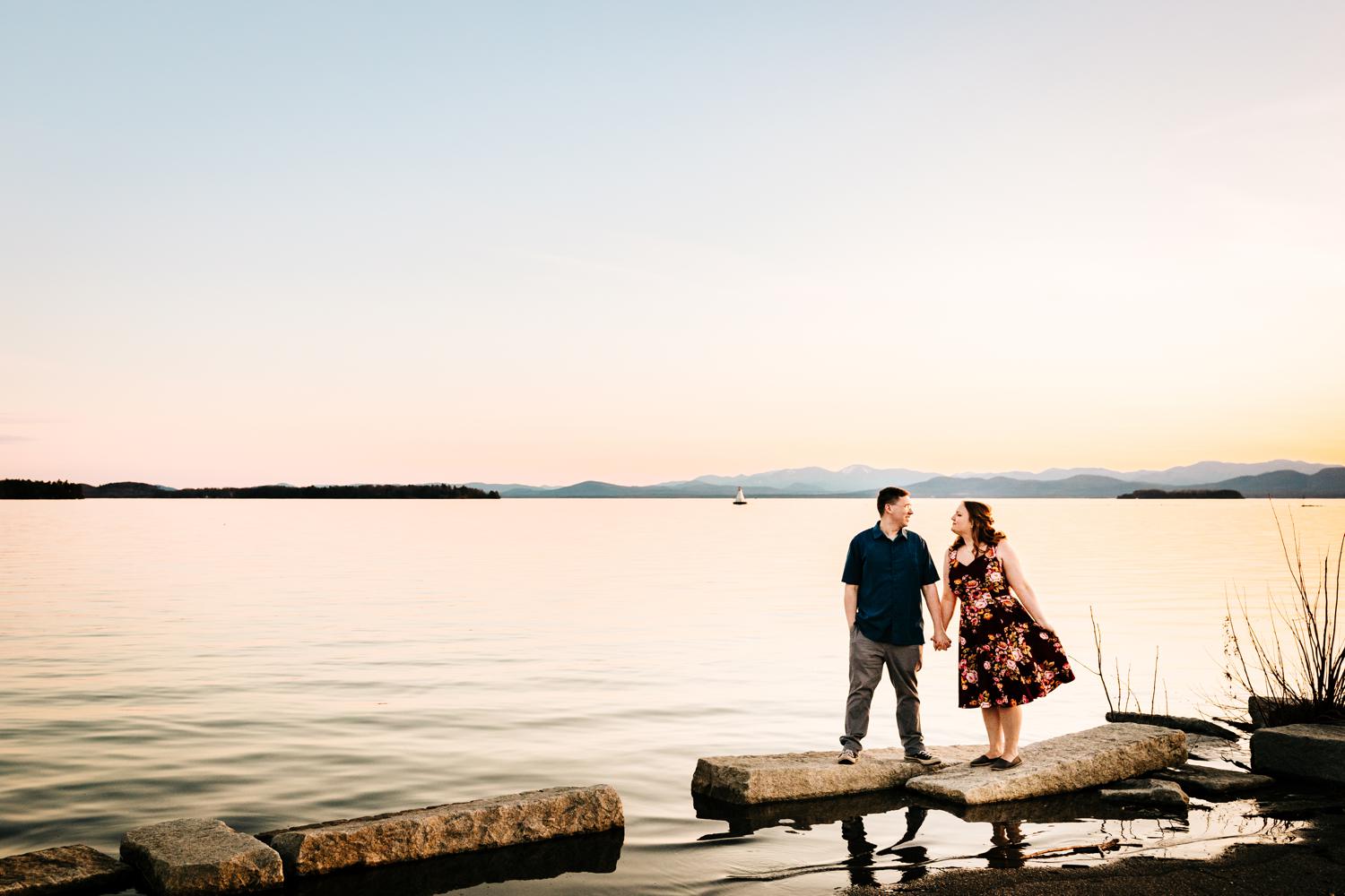 Couple walking along fun lake in front of mountains