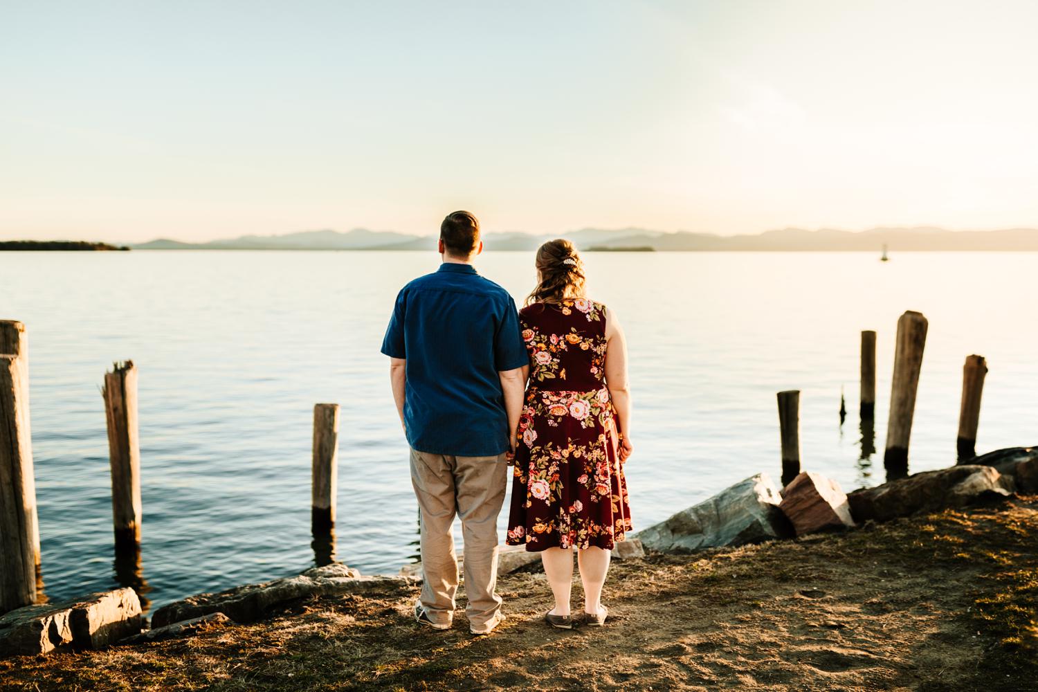 Fun couple looking at mountains and lake at sunset 