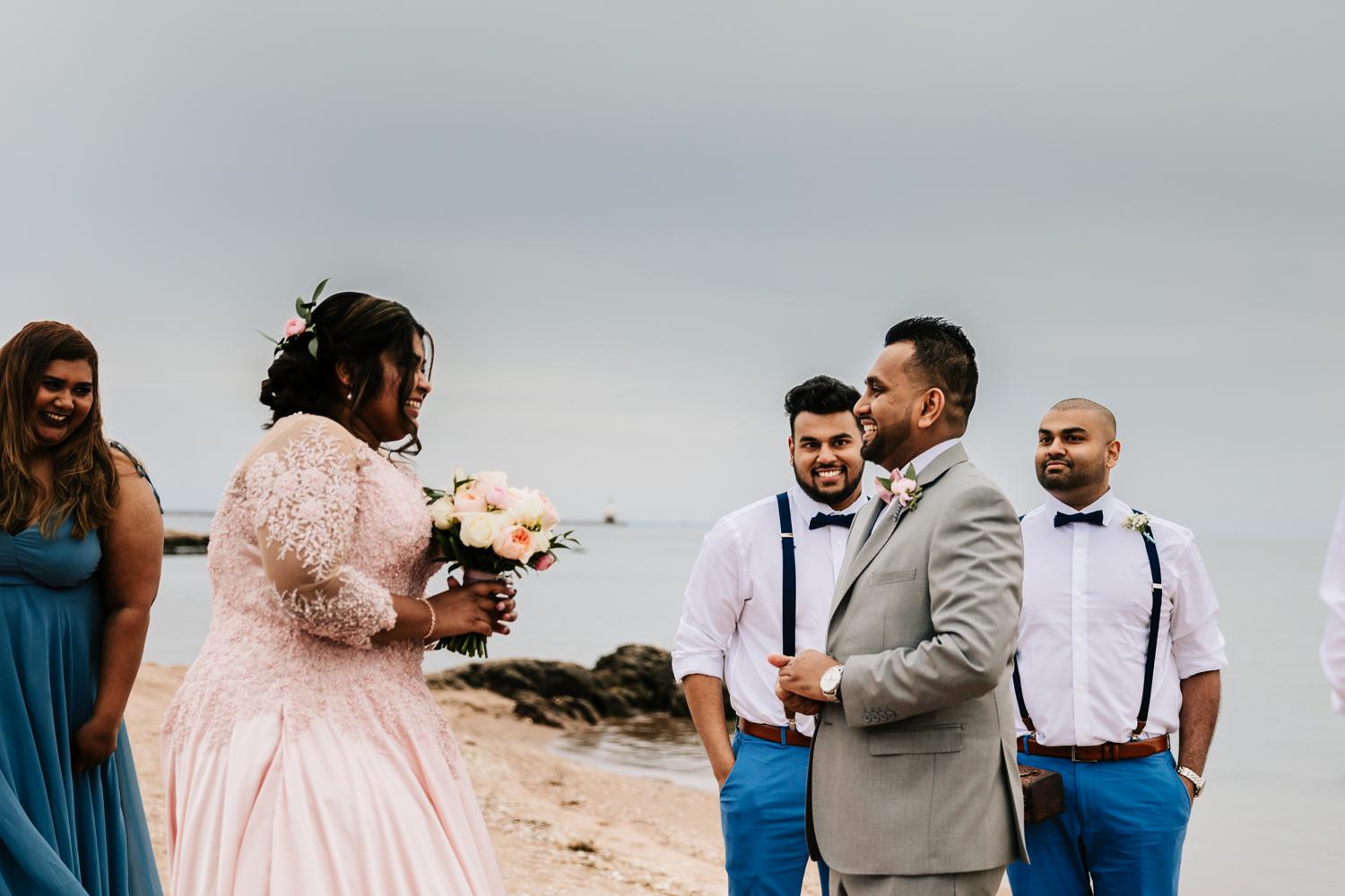 Couple naturally reacting during first look on beach wedding day