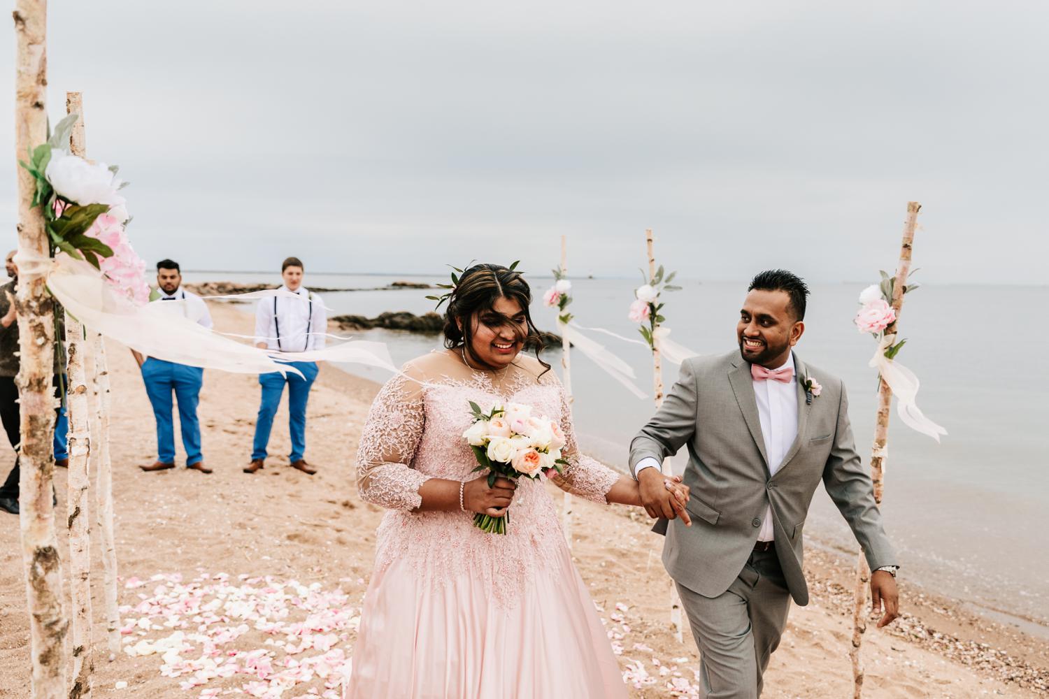 Bride and groom walking down aisle on beach wedding