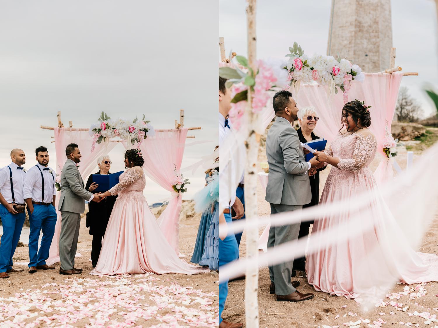 Bride and groom exchanging vows on beach with birch tree decorations