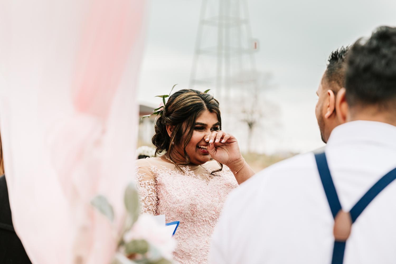 Bride crying while groom gives vows at intimate wedding