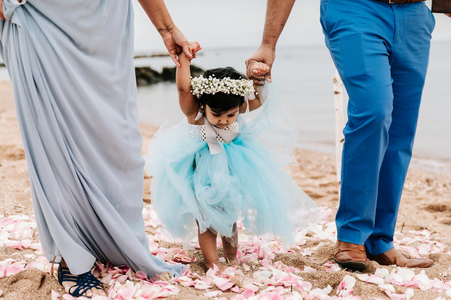 Flower girl baby being walked down aisle