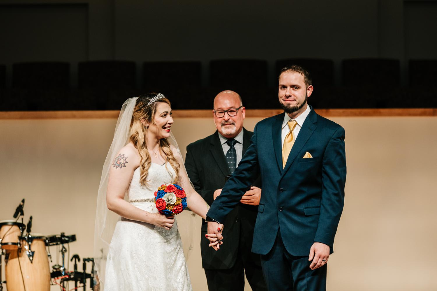 Tattoed bride and groom smiling after ceremony