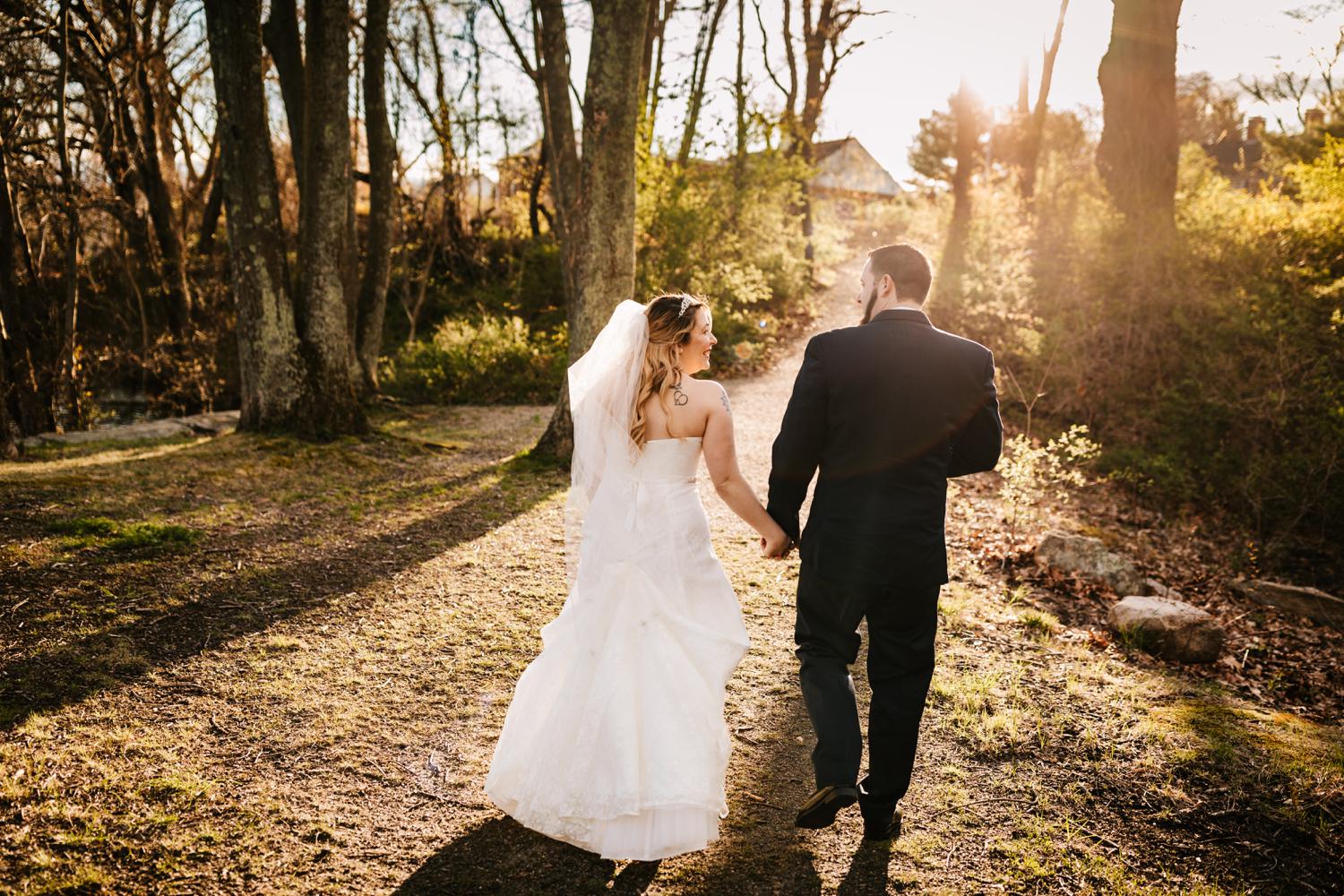 Tattooed bride and groom walking down trail