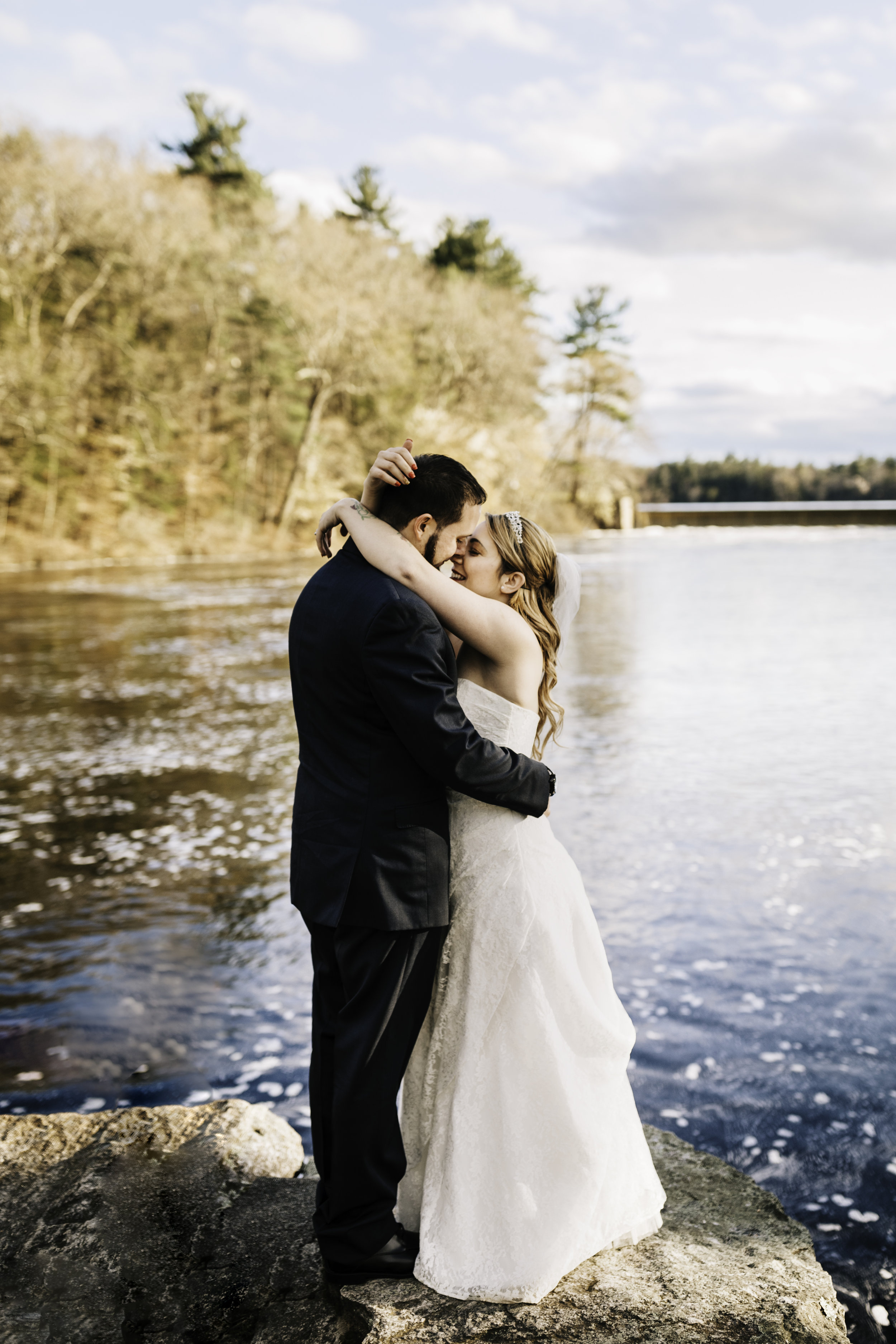 Bride and groom embracing at waterfront