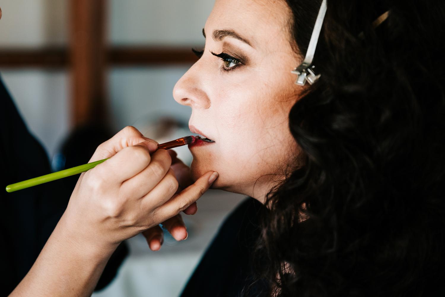 makeup artist putting lipstick on bride for Albuquerque wedding