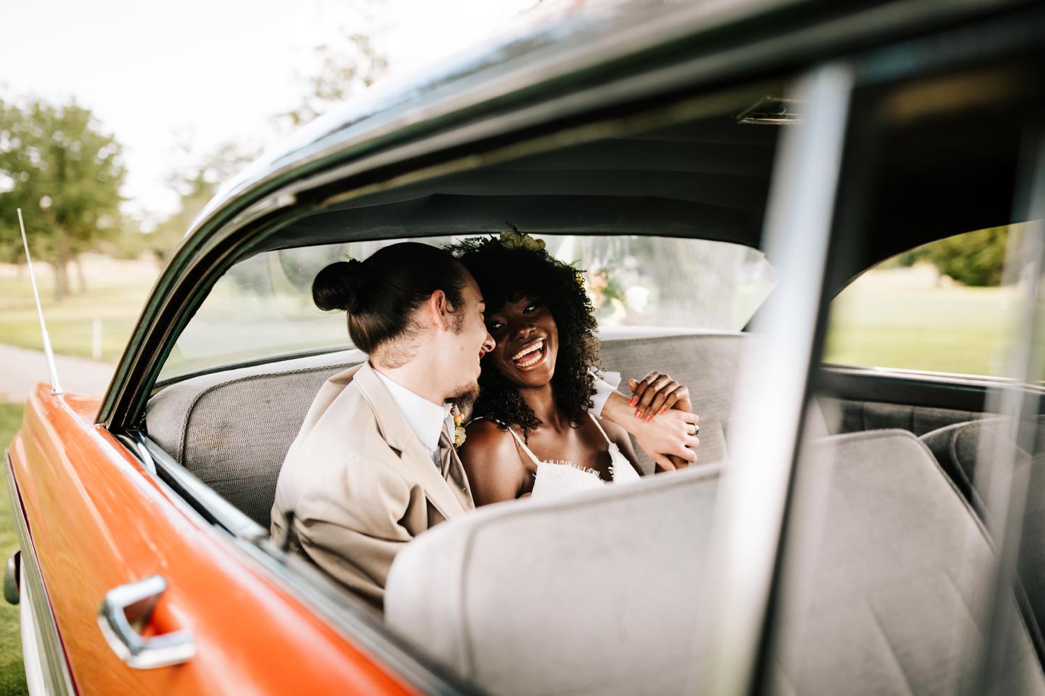 Wedding couple laughing in vintage car in Albuquerque, New Mexico