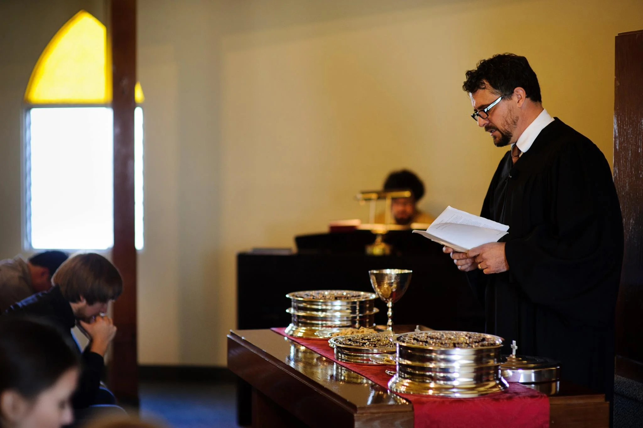 Rev. Michael Brown conducând congregația în închinare prin intermediul formulei liturgice în timpul oficierii sacramentului Cinei Domnului la Biserica Reformată Unită din San Diego .