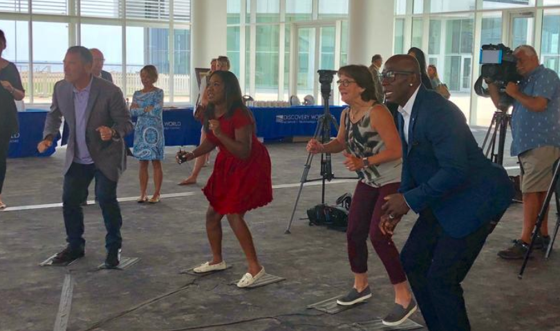 (From left) Milwaukee attorney Jason Abraham, Melinda Davenport of WISN-TV (Channel 12), Olympic speedskater Bonnie Blair and former Green Bay Packers wide receiver Donald Driver test out a virtual reality sausage race game.