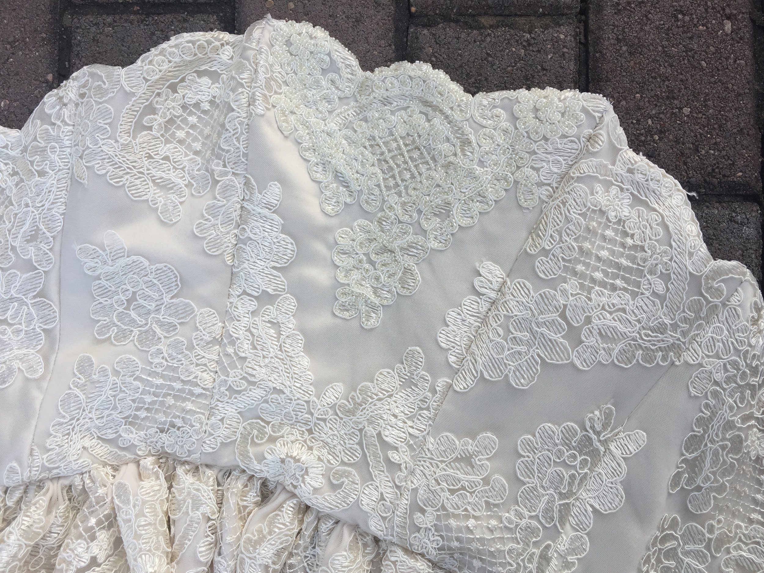 Sneak peek of an ivory mid-length dress with beaded details and scalloped neckline