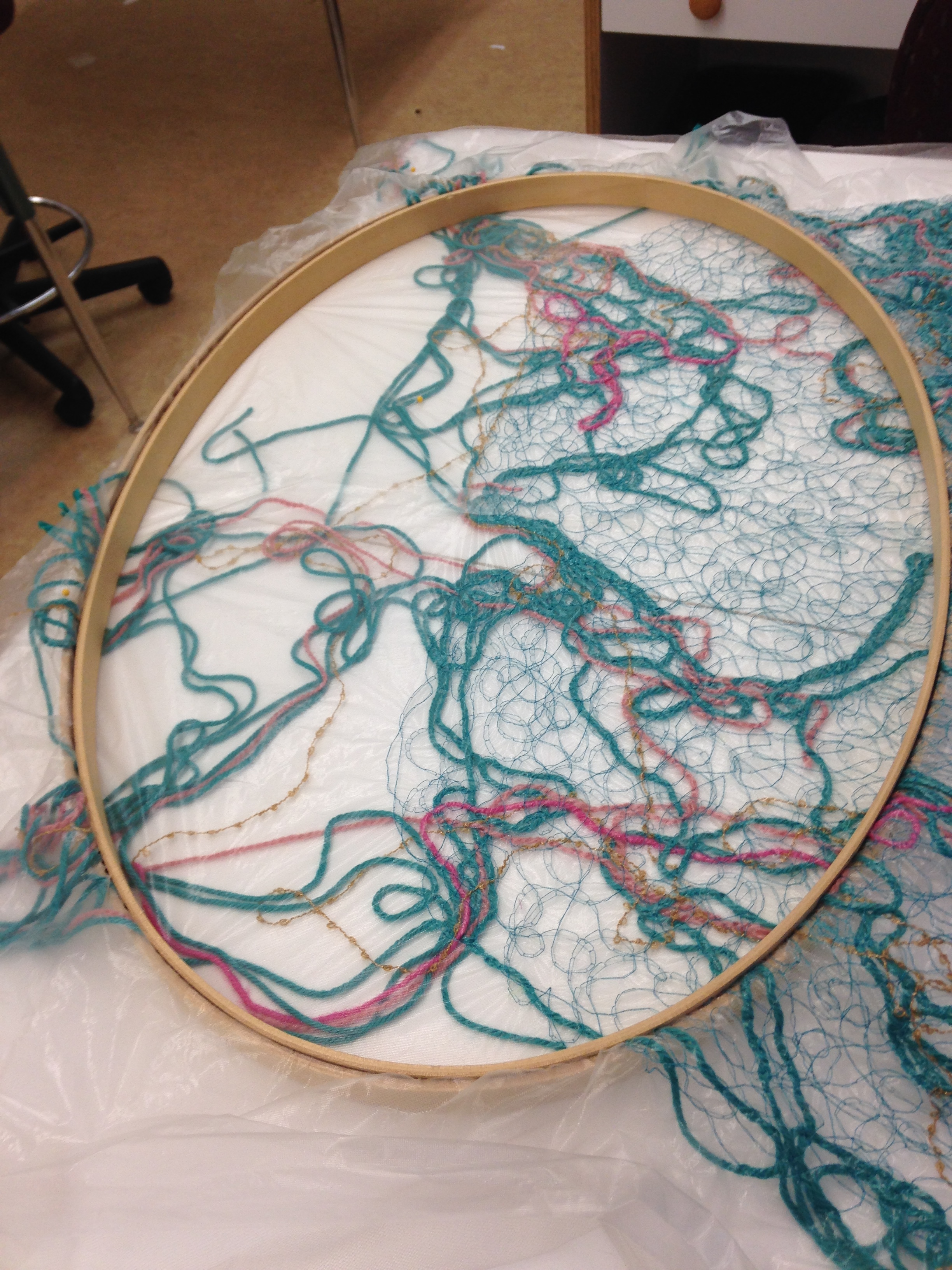 "Yarn collage" fabric stretched into a frame for quilting.
