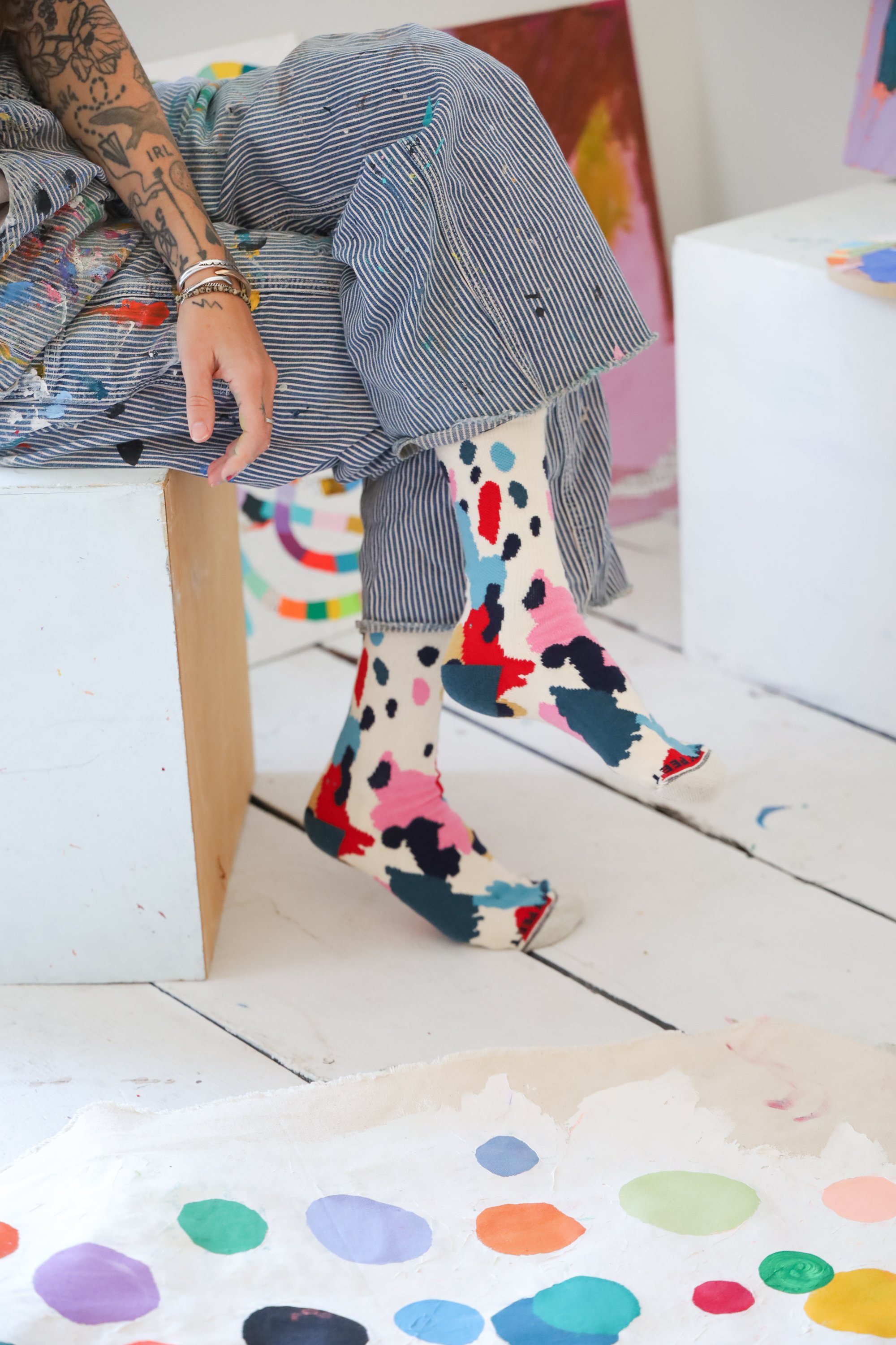 CHippy Feet "Painted Socks" by Ashley Mary, featuring a cream-colored base layered with an abundance of colorful paint splotches and abstract textures.