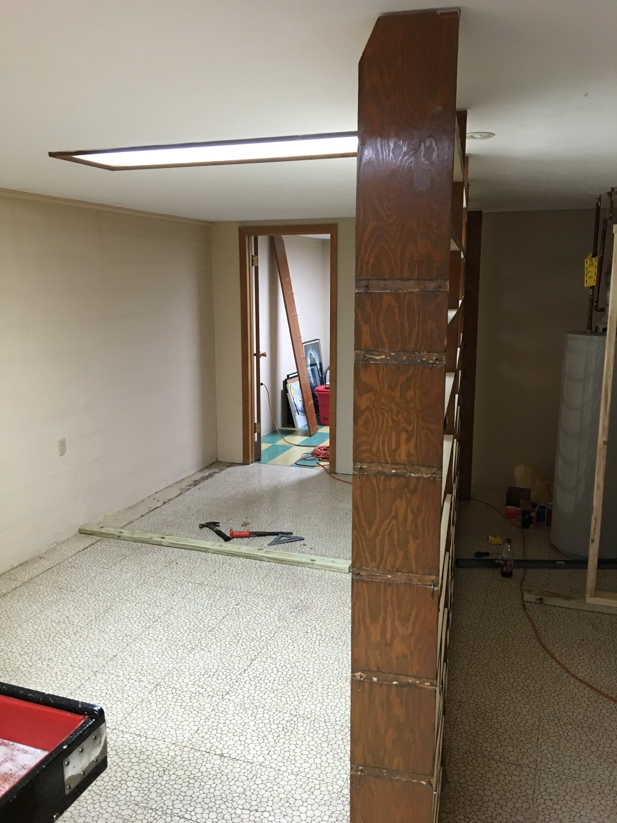 First step - removing the shelving and creating a room for the water heater. My brother who has a lot more experience in this kind of thing helped me with framing the room.