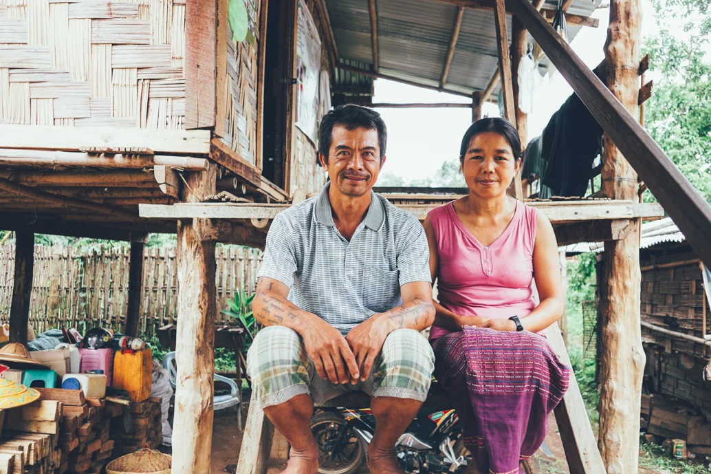 Shan village leader and his wife at the front steps to their home.