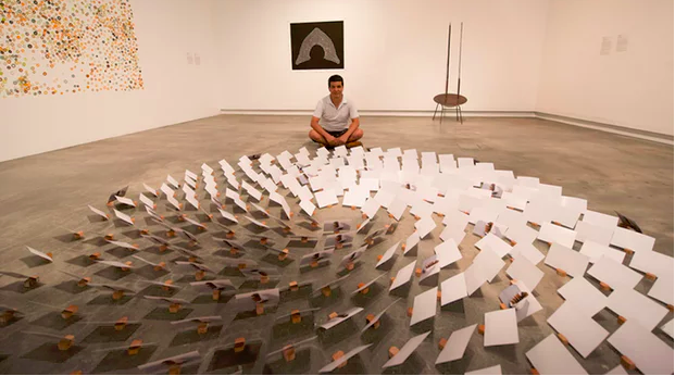 Hazara refugee Sha Sarwari with his floor-based installation Silent Conversation, featuring 1,975 blank postcards. Photograph: Michael Cranfield